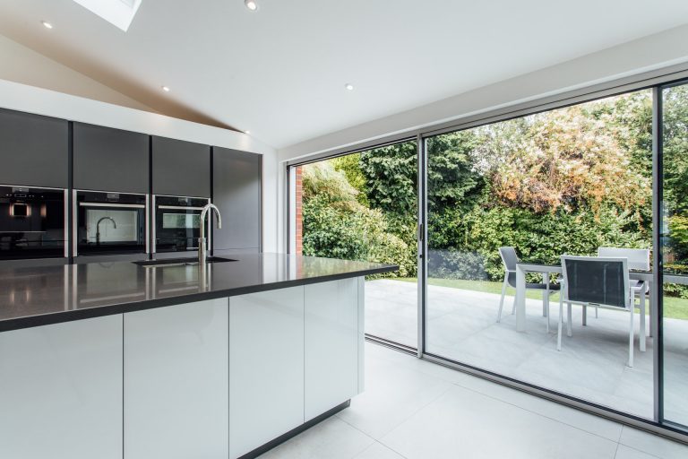 Slim-profile Solarlux sliding doors in a flat-roof extension