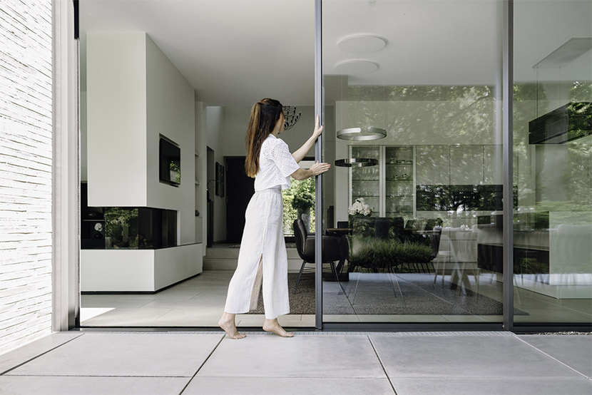 Cero triple-glazing sliders being opened by a young lady